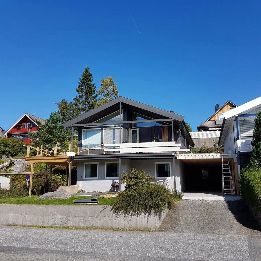 Huset med ferdig carport og terrasse sett fra gaten